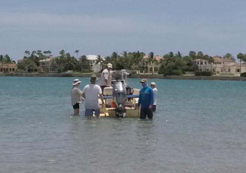 A view of people in the water beside a boat at Jupiter Inlet